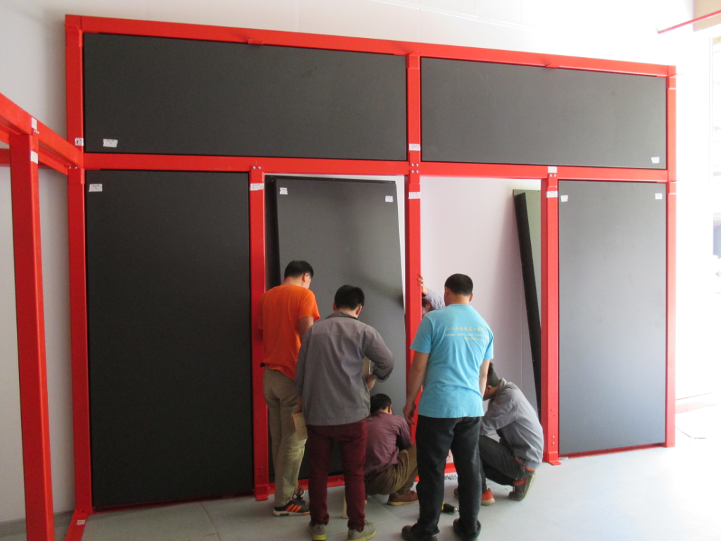 Chinese students assembling facility cell wall from red beams and black panels