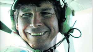 Close-up of Pilot David Black face, smiling wearing headset sitting in aircraft cockpit