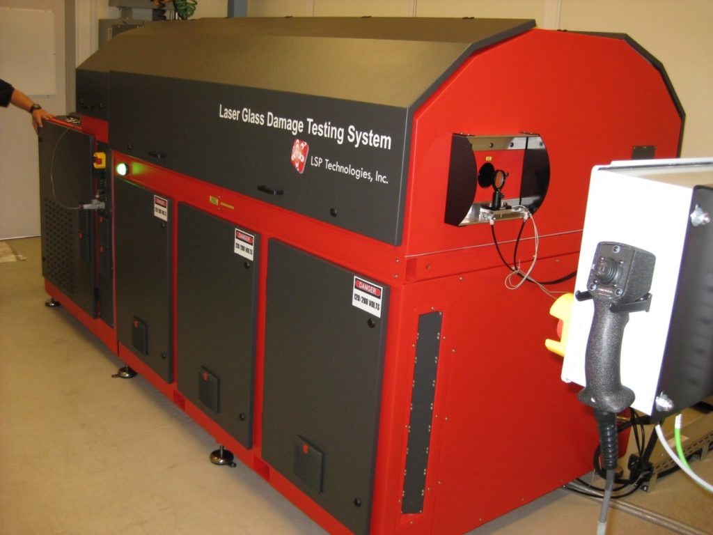 Laser Glass Damage Testing System - Red and black enclosure in manufacturing facility