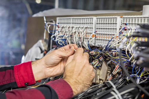an employee fixing wires on a machine