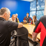 LSPT employees standing around a long wooden table