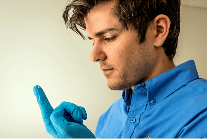 Optics - Optical engineer Tim Gorman examines a microlens. 